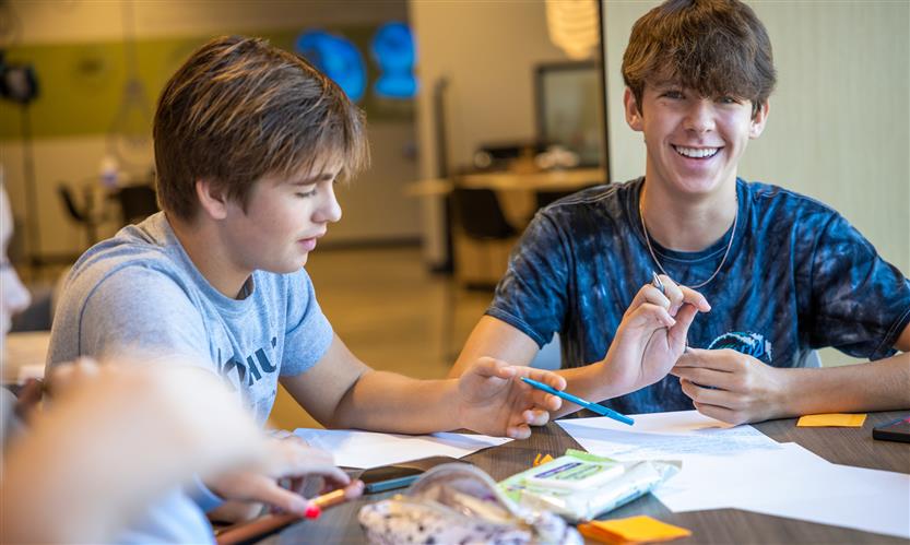 A student smiles while talking with a group